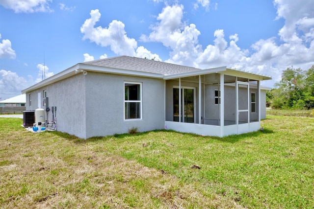 2438 W Wellston Rd, Avon Park, FL 33825 - rear view of property with a sunroom, cooling unit, stucco siding, and a lawn