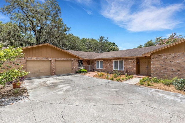 6819 Broken Arrow Trl S, Lakeland, FL 33813 - single story home featuring brick siding, an attached garage, concrete driveway, board and batten siding, and a shingled roof