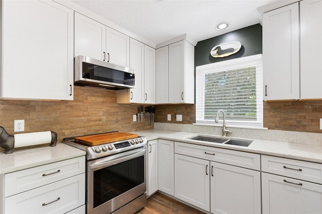 6819 Broken Arrow Trl S, Lakeland, FL 33813 - kitchen with appliances with stainless steel finishes, light countertops, white cabinets, decorative backsplash, and recessed lighting