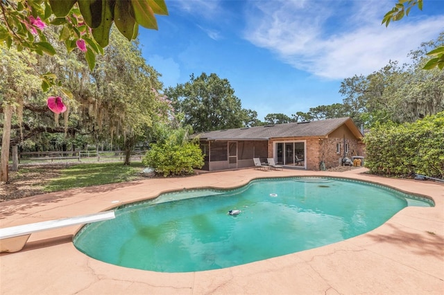 6819 Broken Arrow Trl S, Lakeland, FL 33813 - view of swimming pool featuring a sunroom, a patio area, and a diving board
