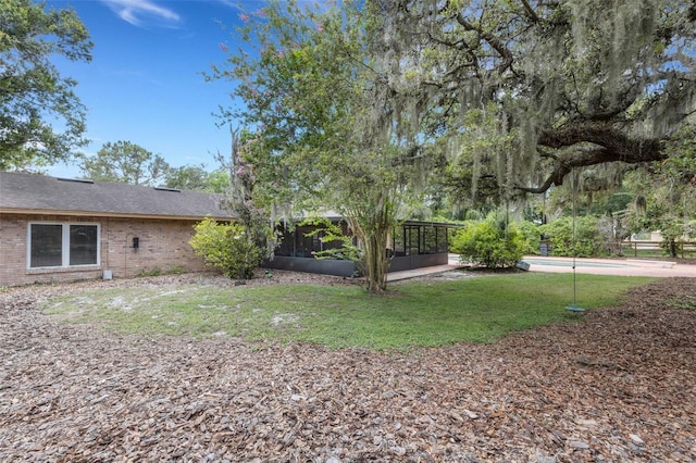 6819 Broken Arrow Trl S, Lakeland, FL 33813 - view of grassy yard featuring a sunroom and an outdoor pool