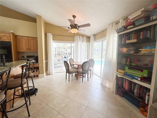 1909 Masters Way, Plant City, FL 33566 - dining area with lofted ceiling, a ceiling fan, light tile patterned flooring, and a textured ceiling