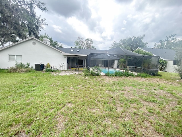 1909 Masters Way, Plant City, FL 33566 - rear view of property with a yard, glass enclosure, a chimney, an outdoor pool, and stucco siding