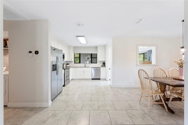 818 Woodward St, Lakeland, FL 33803 - kitchen featuring appliances with stainless steel finishes, a sink, white cabinetry, light stone countertops, and baseboards