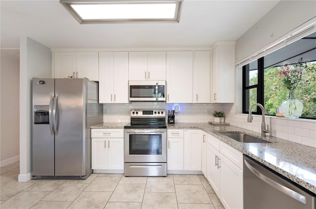 818 Woodward St, Lakeland, FL 33803 - kitchen with appliances with stainless steel finishes, a sink, backsplash, and white cabinetry