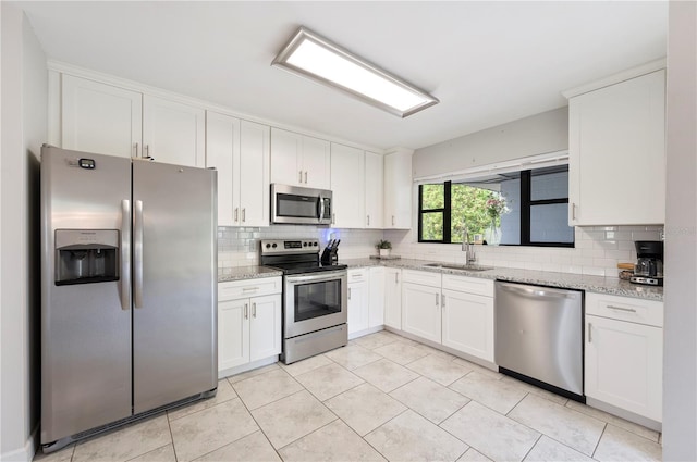 818 Woodward St, Lakeland, FL 33803 - kitchen with stainless steel appliances, a sink, backsplash, and white cabinets