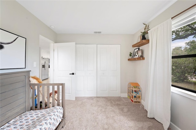 818 Woodward St, Lakeland, FL 33803 - bedroom with stainless steel fridge with ice dispenser, carpet floors, and a closet