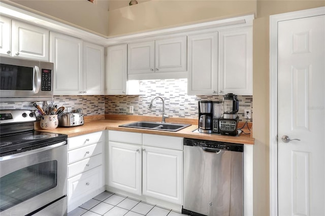 1300 Ariana Woods Cir, Auburndale, FL 33823 - kitchen with stainless steel appliances, tasteful backsplash, white cabinets, and light tile patterned floors