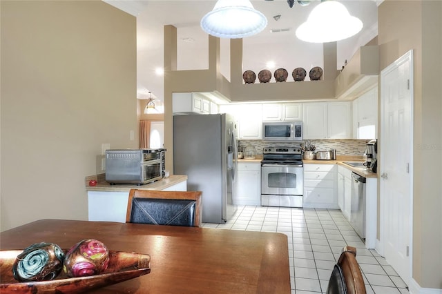 1300 Ariana Woods Cir, Auburndale, FL 33823 - kitchen featuring appliances with stainless steel finishes, tasteful backsplash, light tile patterned floors, and white cabinetry