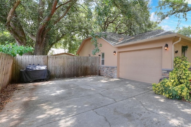 1300 Ariana Woods Cir, Auburndale, FL 33823 - view of property exterior with stucco siding, stone siding, concrete driveway, and a garage