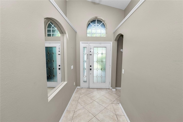 16804 Hawkridge Rd, Lithia, FL 33547 - foyer entrance featuring baseboards, light tile patterned floors, a high ceiling, and arched walkways