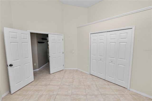 16804 Hawkridge Rd, Lithia, FL 33547 - unfurnished bedroom with light tile patterned floors, a closet, baseboards, and a towering ceiling