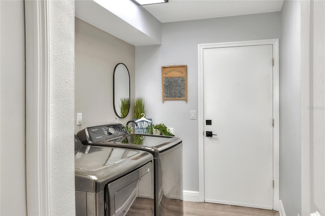8721 Latham Ln, Hudson, FL 34667 - laundry room with separate washer and dryer, wood finished floors, and baseboards