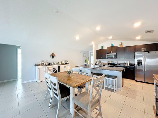 2929 Flying Blackbird Rd, Bartow, FL 33830 - kitchen featuring stainless steel appliances, vaulted ceiling, light tile patterned floors, dark brown cabinets, and an island with sink