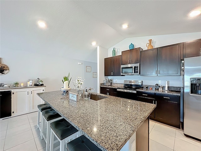 2929 Flying Blackbird Rd, Bartow, FL 33830 - kitchen featuring appliances with stainless steel finishes, a sink, vaulted ceiling, a breakfast bar area, and light tile patterned flooring