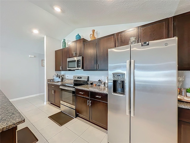 2929 Flying Blackbird Rd, Bartow, FL 33830 - kitchen featuring stainless steel appliances, lofted ceiling, dark brown cabinets, stone counters, and light tile patterned flooring