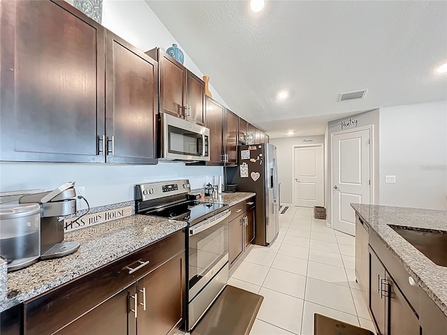 2929 Flying Blackbird Rd, Bartow, FL 33830 - kitchen with stainless steel appliances, light tile patterned floors, light stone counters, dark brown cabinets, and recessed lighting