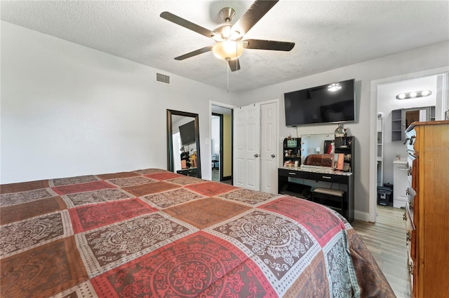 3016 Reiter Dr, Auburndale, FL 33823 - bedroom with light wood-style floors, a textured ceiling, a ceiling fan, and an office area