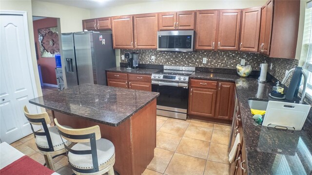 2170 Forest Lake Ave, Dundee, FL 33838 - kitchen with stainless steel appliances, tasteful backsplash, a kitchen bar, a center island, and light tile patterned floors