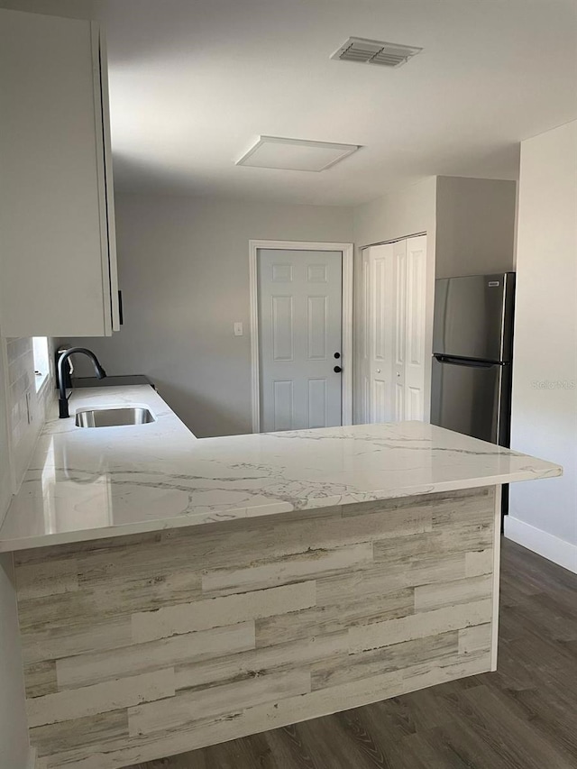 854 Shirley Ann Trl Unit 854/856, Lakeland, FL 33809 - kitchen featuring a sink, freestanding refrigerator, dark wood-style flooring, light stone counters, and baseboards