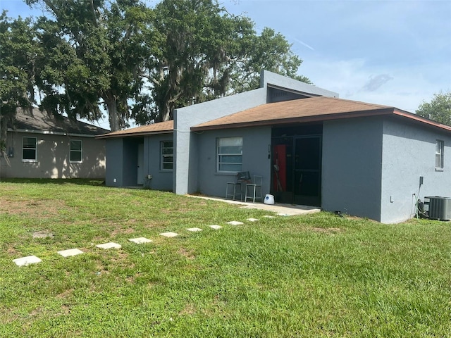854 Shirley Ann Trl Unit 854/856, Lakeland, FL 33809 - rear view of property with stucco siding, a yard, cooling unit, and a shingled roof