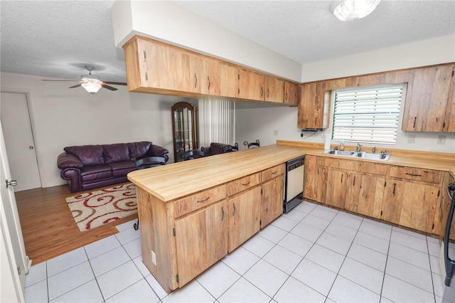 1917 Lori Ln W, Lakeland, FL 33801 - kitchen with a sink, dishwashing machine, a textured ceiling, a peninsula, and ceiling fan