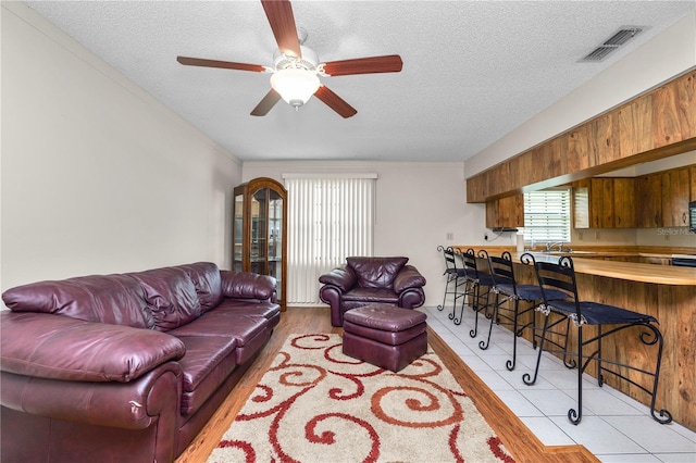 1917 Lori Ln W, Lakeland, FL 33801 - living room featuring a textured ceiling, ceiling fan, and light tile patterned floors