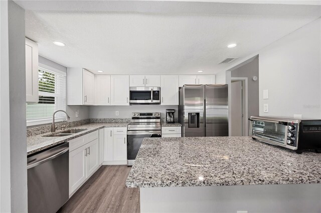 3080 Cross Fox Dr, Mulberry, FL 33860 - kitchen with appliances with stainless steel finishes, a sink, white cabinetry, light stone counters, and recessed lighting