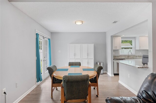 3080 Cross Fox Dr, Mulberry, FL 33860 - dining room featuring light wood-style floors, a textured ceiling, and baseboards