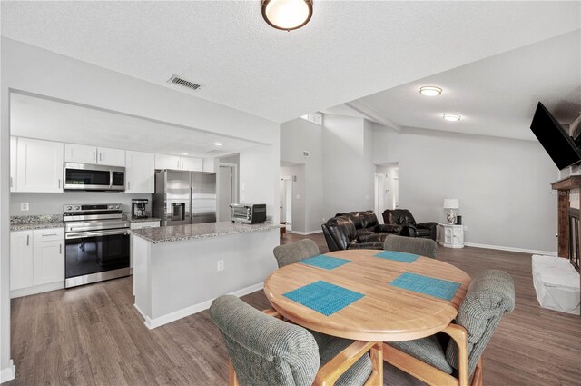 3080 Cross Fox Dr, Mulberry, FL 33860 - dining space featuring wood finished floors, baseboards, a textured ceiling, and a fireplace with raised hearth