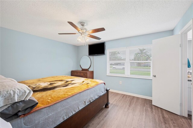 3080 Cross Fox Dr, Mulberry, FL 33860 - bedroom with wood finished floors, a textured ceiling, a ceiling fan, and baseboards