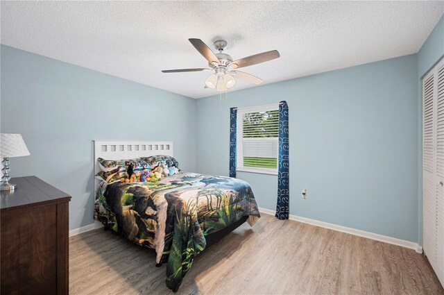 3080 Cross Fox Dr, Mulberry, FL 33860 - bedroom with wood finished floors, baseboards, a ceiling fan, a textured ceiling, and a closet