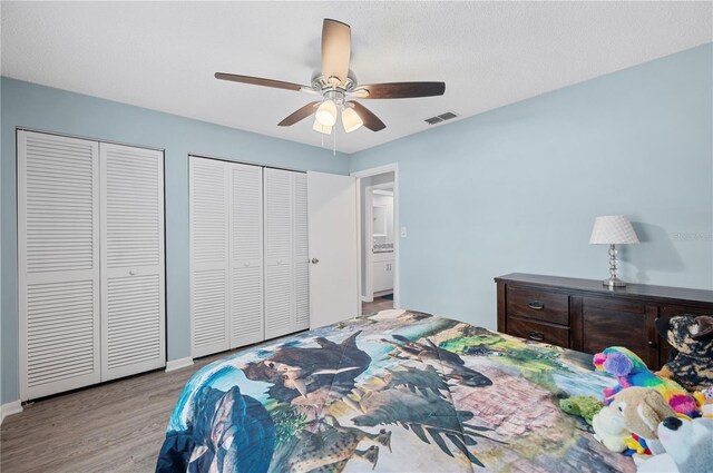 3080 Cross Fox Dr, Mulberry, FL 33860 - bedroom featuring two closets, wood finished floors, a ceiling fan, and baseboards