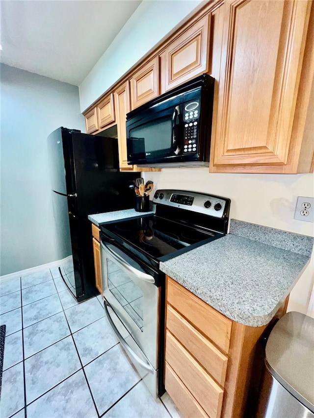 355 Pico Ct, Lakeland, FL 33809 - kitchen featuring black appliances, light tile patterned flooring, light countertops, baseboards, and light brown cabinetry