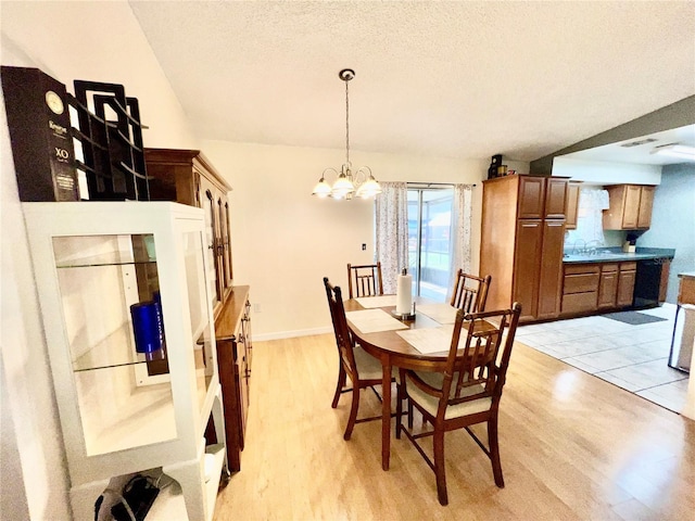 355 Pico Ct, Lakeland, FL 33809 - dining space with light wood-style flooring, a chandelier, and a textured ceiling