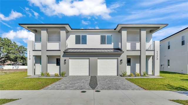 1170 Windjammer Dr, Lakeland, FL 33803 - view of front of house with stucco siding, decorative driveway, a balcony, a garage, and a standing seam roof