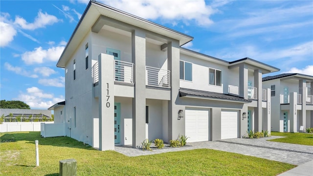 1170 Windjammer Dr, Lakeland, FL 33803 - view of front of home featuring stucco siding, a balcony, a garage, decorative driveway, and a metal roof