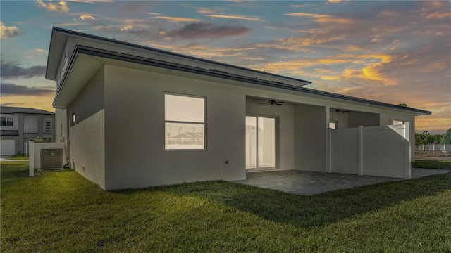 1170 Windjammer Dr, Lakeland, FL 33803 - back of property at dusk with stucco siding and a yard