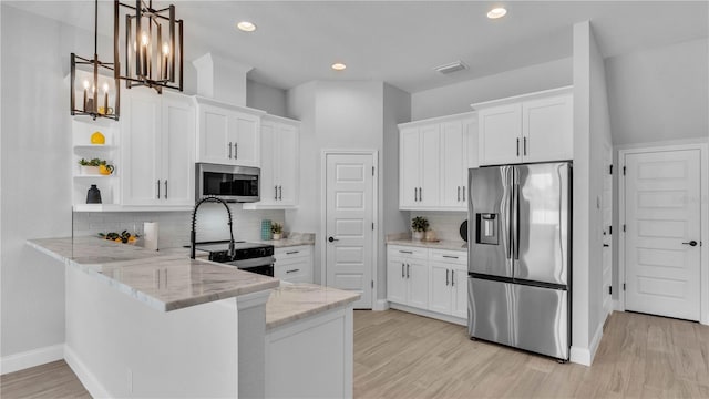 1170 Windjammer Dr, Lakeland, FL 33803 - kitchen with appliances with stainless steel finishes, open shelves, a peninsula, white cabinets, and light wood finished floors