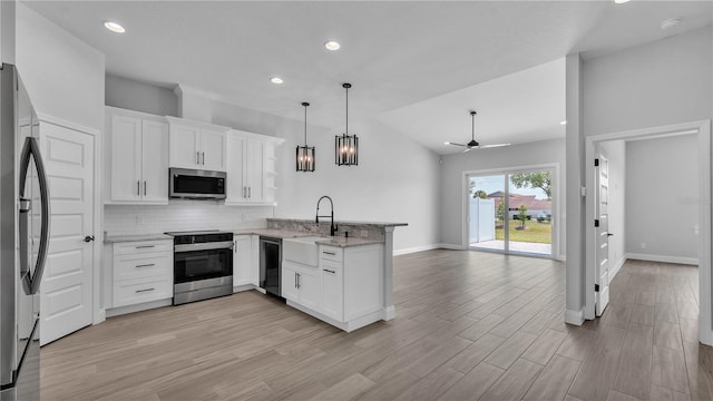 1170 Windjammer Dr, Lakeland, FL 33803 - kitchen featuring appliances with stainless steel finishes, a peninsula, a ceiling fan, backsplash, and white cabinets