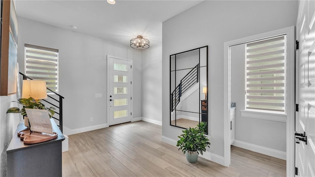 1172 Windjammer Dr, Lakeland, FL 33803 - foyer with stairs, light wood-style flooring, and a chandelier