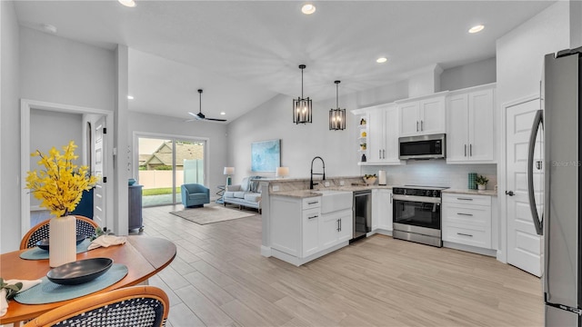 1172 Windjammer Dr, Lakeland, FL 33803 - kitchen featuring appliances with stainless steel finishes, a peninsula, open floor plan, white cabinetry, and tasteful backsplash