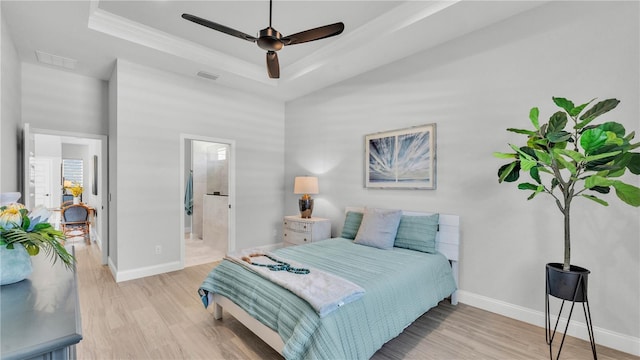 1172 Windjammer Dr, Lakeland, FL 33803 - bedroom with a tray ceiling, light wood-style flooring, ensuite bathroom, and ceiling fan