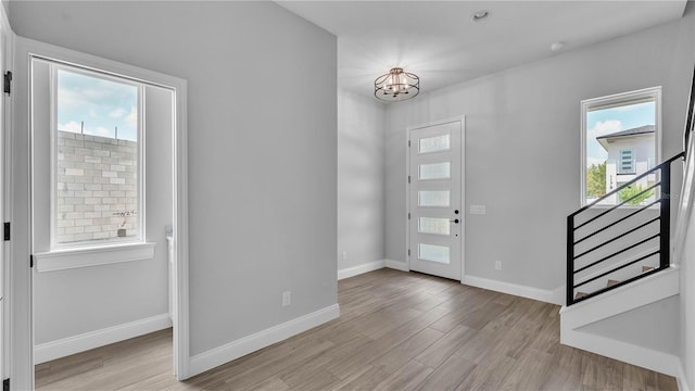 1172 Windjammer Dr, Lakeland, FL 33803 - entrance foyer featuring a chandelier, light wood-style flooring, healthy amount of natural light, and stairway