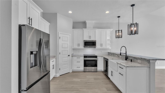 1172 Windjammer Dr, Lakeland, FL 33803 - kitchen featuring stainless steel appliances, a peninsula, light stone counters, light wood finished floors, and recessed lighting
