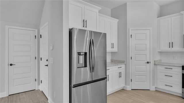 1172 Windjammer Dr, Lakeland, FL 33803 - kitchen featuring stainless steel fridge, light wood-style flooring, white cabinetry, and light stone countertops