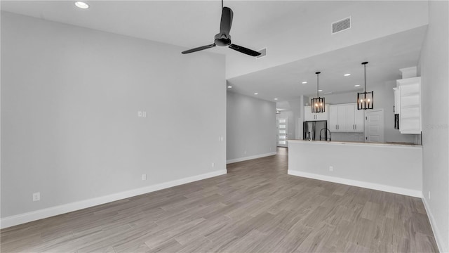 1172 Windjammer Dr, Lakeland, FL 33803 - unfurnished living room with a ceiling fan, recessed lighting, light wood-type flooring, and a chandelier