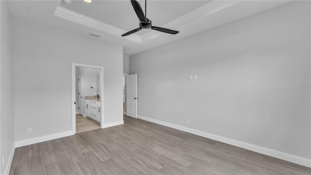 1172 Windjammer Dr, Lakeland, FL 33803 - unfurnished bedroom featuring a tray ceiling, light wood finished floors, ensuite bath, ornamental molding, and a ceiling fan