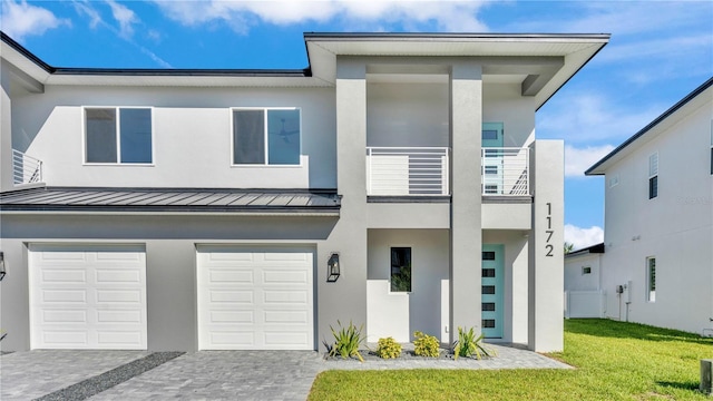 1172 Windjammer Dr, Lakeland, FL 33803 - view of front of house with a standing seam roof, a garage, decorative driveway, stucco siding, and a balcony