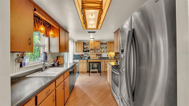 841 E Valencia St, Lakeland, FL 33805 - kitchen with stainless steel appliances, a sink, open shelves, dark countertops, and light wood-type flooring